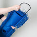 A woman holding a blue Lavex Microfiber Dust Mop Pad.