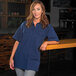 A woman wearing a navy blue Mercer Culinary work shirt.