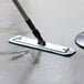 A Lavex blue aluminum mop handle being used to clean a floor.