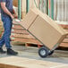 A man using a Lavex hand truck to move a large box.