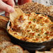 A person holding a cracker with Handy Lump Crab Meat dip.