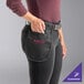 A woman wearing a black utility pouch apron with two pockets.
