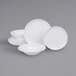 A stack of white plates and bowls with a white plate on top.