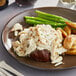 A plate of Handy Colossal Lump Crab Meat with a steak and asparagus on a table.