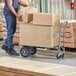 A man using a Lavex convertible hand truck to move boxes.