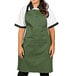 A woman wearing a Uncommon Chef sea green bib apron with black webbing.