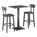 A slate gray industrial-style bar height table with a square top and two matching bar stools with backs.