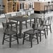 A Lancaster Table & Seating slate gray wood table with chairs next to it.
