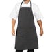 A man wearing a gray apron with triple black pinstripes.