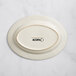 An ivory oval stoneware platter with an embossed rim and black text reading "Acopa" on it.