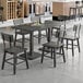 A Lancaster Table & Seating Industrial live edge wood table and chairs in a room.