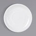 A white Tuxton porcelain saucer with a circle on a gray background.