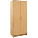 A Tot Mate maple wooden tall cabinet with two doors.