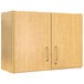 A Tot Mate maple laminate wall cabinet with silver handles.