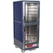 A blue and silver Metro C5 heated holding cabinet with wheels and clear Dutch doors.
