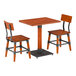 A rustic mahogany finish solid wood table with a live edge and two matching industrial-style chairs.