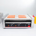 Hot dogs cooking on a Vollrath hot dog roller grill.