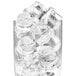 A clear glass filled with gourmet ice cubes, some of which are broken.