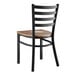 A Lancaster Table & Seating black metal ladder back chair with a vintage wood seat.