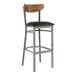 A Lancaster Table & Seating black vinyl and vintage wood bar stool with a metal frame.
