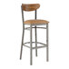 A Lancaster Table & Seating metal bar stool with a brown vinyl cushioned seat and wood back.