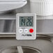 An AvaTime Mini Digital kitchen timer on a stainless steel counter.