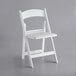 A white Lancaster Table & Seating folding chair with a vinyl seat.