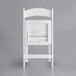 A white Lancaster Table & Seating folding chair with a white vinyl seat.