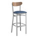 A Lancaster Table & Seating bar stool with a blue vinyl seat and wood back.