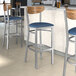 Lancaster Table & Seating Boomerang bar stools with blue vinyl seats and vintage wood backs.