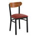 A black metal chair with a burgundy vinyl seat and a curved vintage wood backrest.