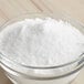 A bowl of LorAnn Baker's Ammonia white powder on a wooden table.