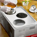 A person using a ServIt adapter plate to prepare soup.
