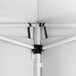 A close-up view of the interior frame and corner joint of a white steel pop-up canopy tent with attached fabric side walls.