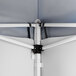 A close-up view of the interior frame and corner connection of a blue pop-up canopy tent with attached side walls.