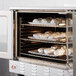 A Cooking Performance Group deep depth convection oven with trays of food inside.