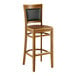 A Lancaster Table & Seating Sofia vintage wood bar stool with a wooden seat.