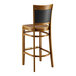 A Lancaster Table & Seating Sofia wood bar stool with a vintage wood seat.