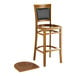 A Lancaster Table & Seating Sofia wood bar stool with a vintage wood seat.