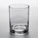 An Arcoroc customizable rocks glass filled with a small amount of liquid on a white background.