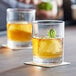 Two Arcoroc ArcoPrime rocks glasses filled with a drink and a lime spiral on top.