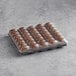 A tray of White Toque French chocolate macarons in plastic.