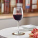 A close up of a glass of red wine on a table.