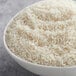 A bowl of Riceland Oriental Style long grain white rice on a table.
