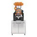 A high-capacity automatic feed juicer with a stainless steel podium, designed for juicing oranges at a rate of 40 fruits per minute.