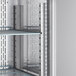 A metal shelf with shelves and lights inside of an Avantco reach-in refrigerator.