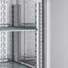 A metal shelf with shelves and lights inside a stainless steel Avantco VersaHub Reach-In Refrigerator.