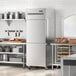 An Avantco stainless steel reach-in refrigerator with solid half doors in a kitchen.