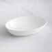 a white oval bowl on a marble surface
