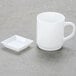 A white square dish with a small handle.